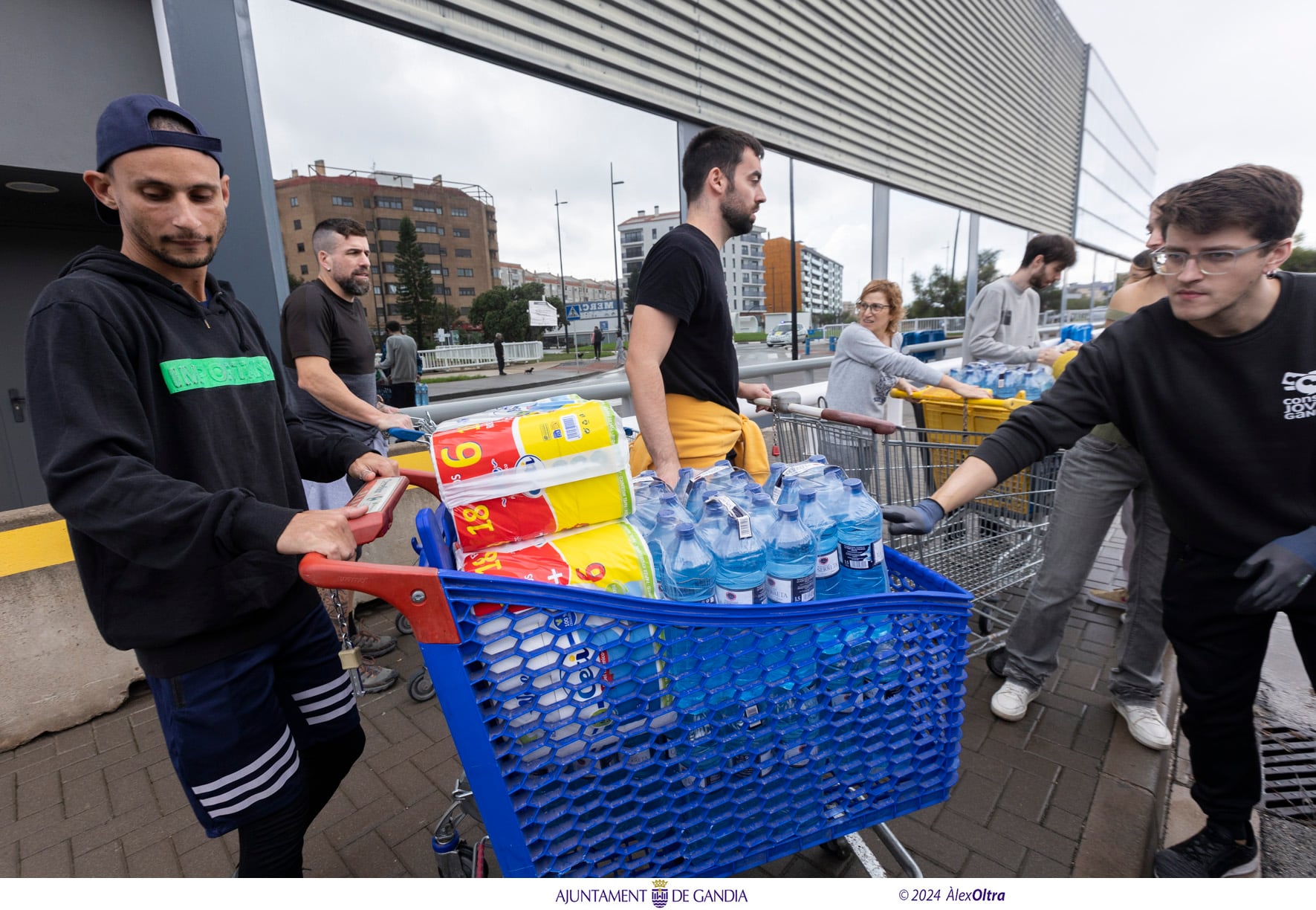 Personas ayudan en la recogidas de alimentos en la sede de la Policía Local de Gandia.