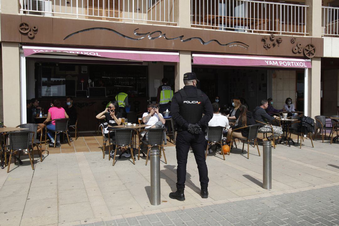 Archivo - Un agente de la Policía Nacional durante un control a una terraza. Archivo.