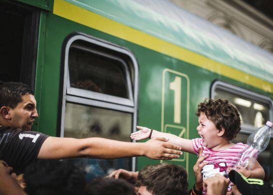 Un joven sirio se despide de una niña en una estación.