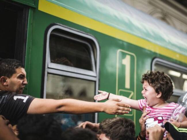 Un joven sirio se despide de una niña en una estación.