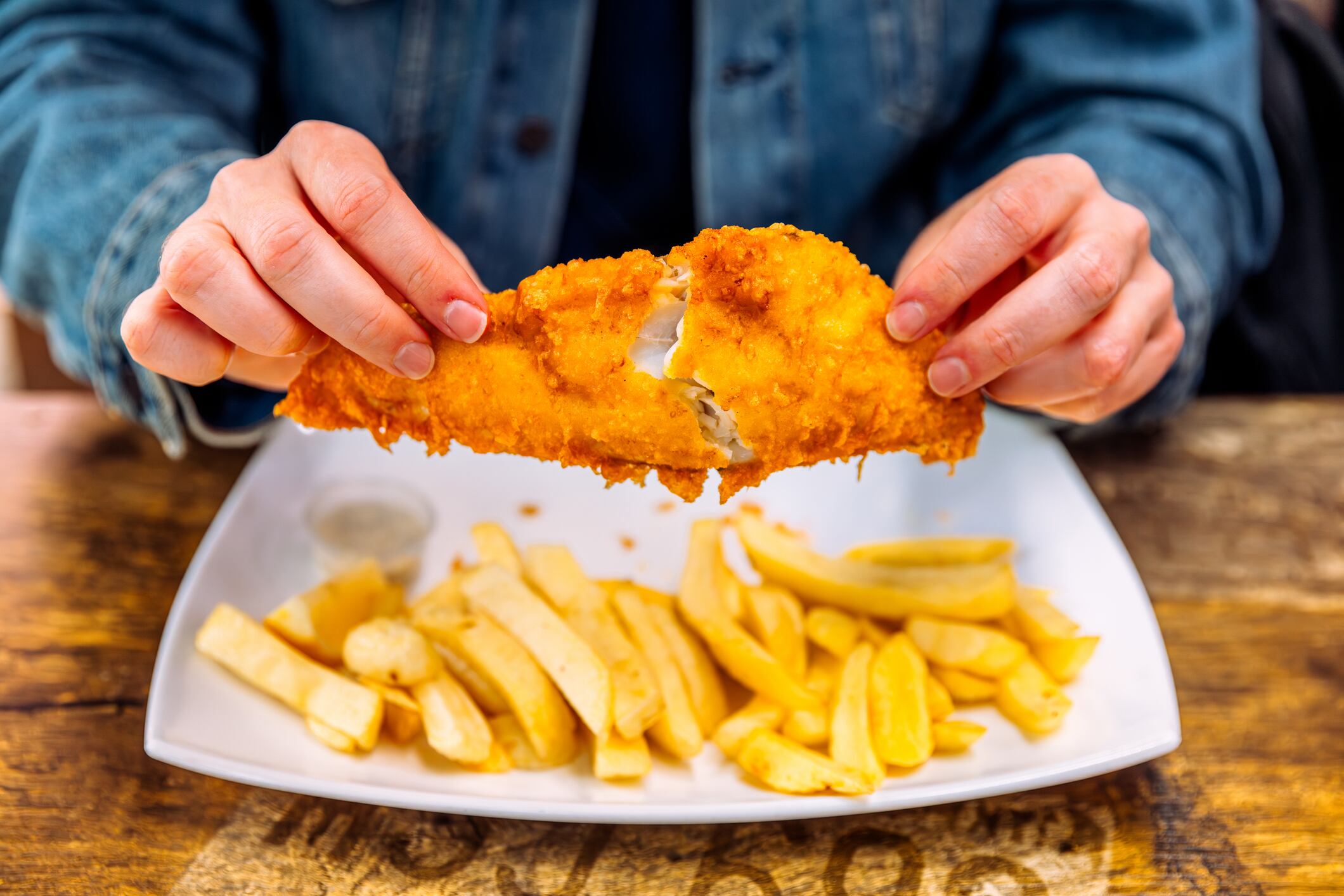 Un hombre comiendo fish & chips.