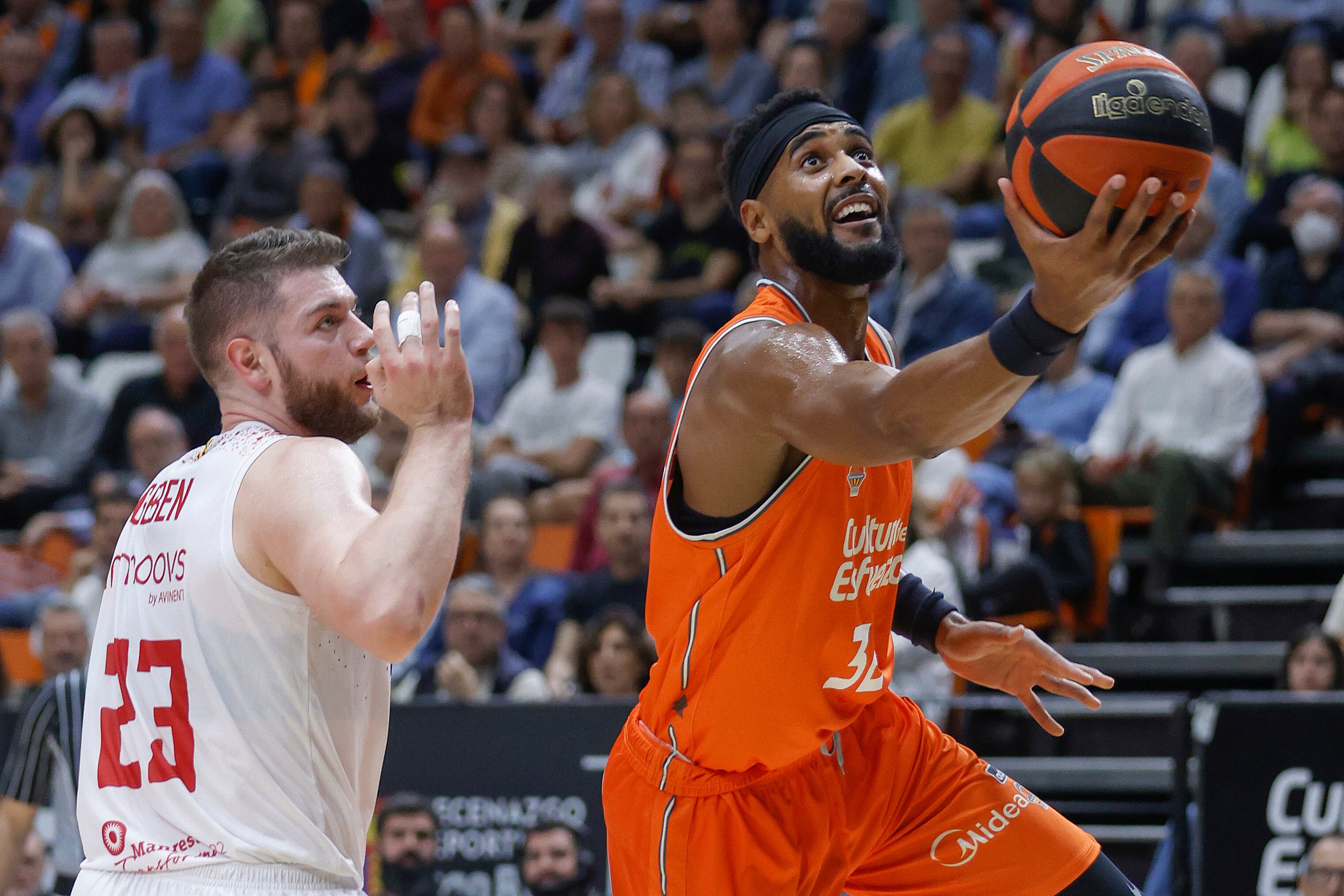 El pívot estadounidense del Valencia Basket Brandon Davies supera al pívot lituano del Baxi Manresa Martynas Geben durante el partido de la liga ACB de baloncesto disputado este domingo en la Fuente de San Luis. EFE/ Miguel Ángel Polo