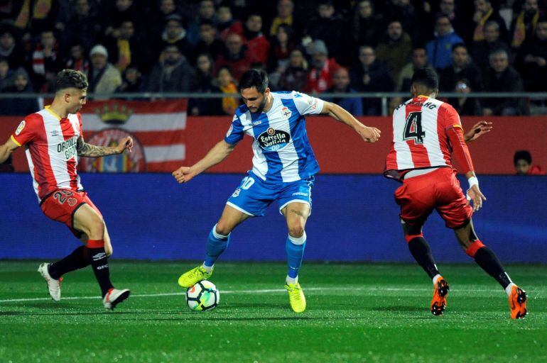 El delantero rumano del Deportivo Florin Andone pelea un balón con los jugadores del Girona Jonás Ramalho y Pablo Maffeo, en partido de liga que se disputa esta noche en el Campo Municipal Montillivi.