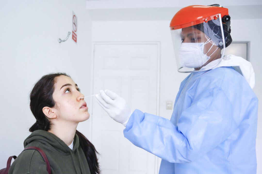 A health worker takes a sample for a PCR test