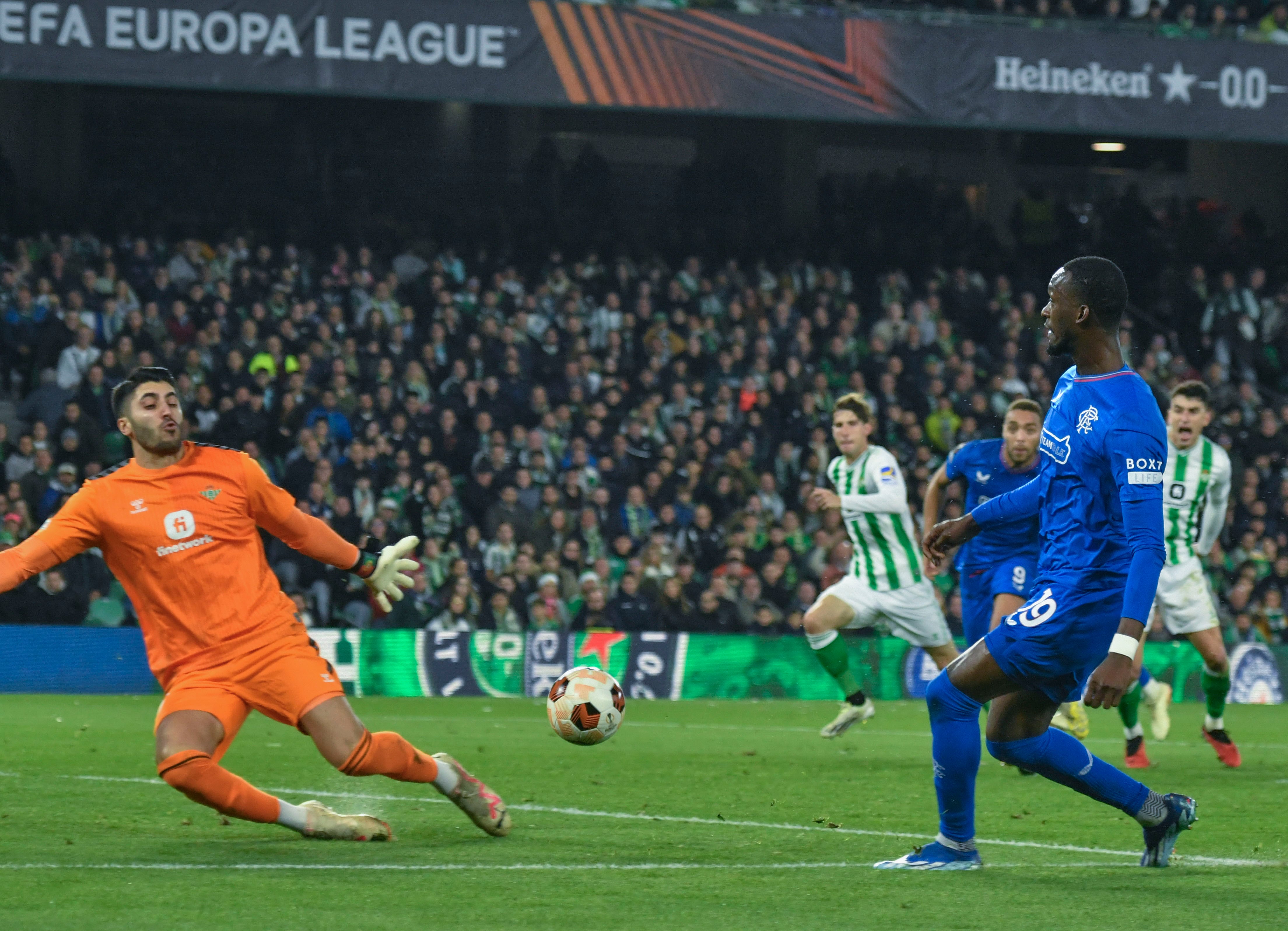 Sevilla, 14/12/2023.- El delantero senegalés del Rangers, Abdallah Sima (d), remata ante el guardameta portugués del Betis, Rui Silva, durante el encuentro correspondiente a la fase de grupos de la Liga Europa que disputan hoy jueves Betis y Rangers en el estadio Benito Villamarín, en Sevilla. EFE/José Manuel Vidal.
