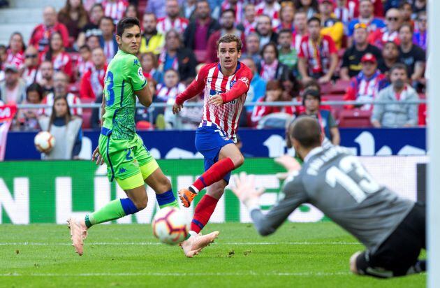El delantero francés del Atlético de Madrid Antoine Griezmann (c) intenta batir al portero del Real Betis Pau López (d) durante el partido de la octava jornada de La Liga, esta tarde en el Estadio Wanda Metropolitano en Madrid.