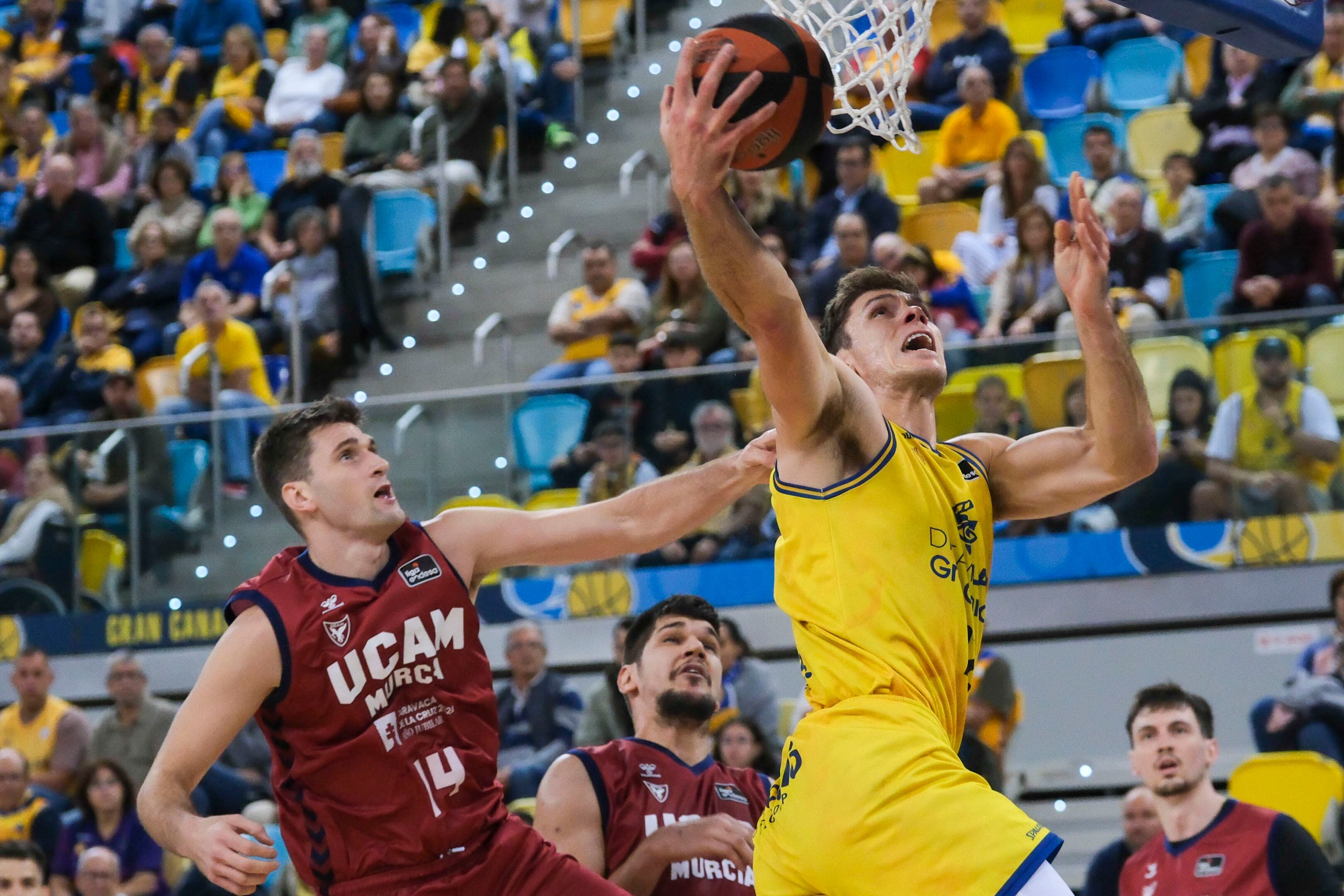 LAS PALMAS DE GRAN CANARIA. 20/01/2024.- El pivot estadounidense del Gran Canaria, Ethan Happ (d), entra a canasta ante su compatriota, el ala-pivot de UCAM Murcia, Dustin Sleva, durante el partido de la decimonovena jornada de la Liga Endesa que ambos equipo han disputado hoy en el Gran Canaria Arena. EFE/Ángel Medina G.
