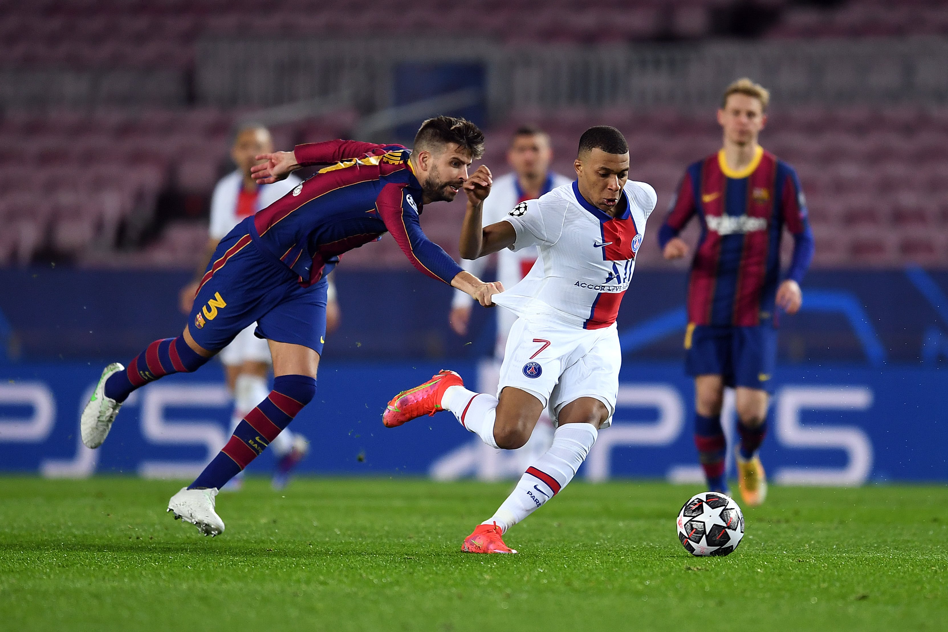 Gerard Piqué agarra de la camiseta a Mbappé durante una eliminatoria de Champions League