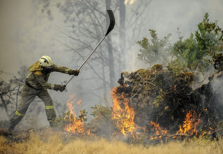 Un brigadista realiza labores de extinción ante el incendio forestal registrado en el ayuntamiento de Ourense en la parroquia de Castro de Beiro