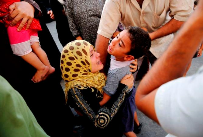 Una mujer palestina abraza a su hijo tras encontrarlo con vida en un hospital al norte de la Franja de Gaza