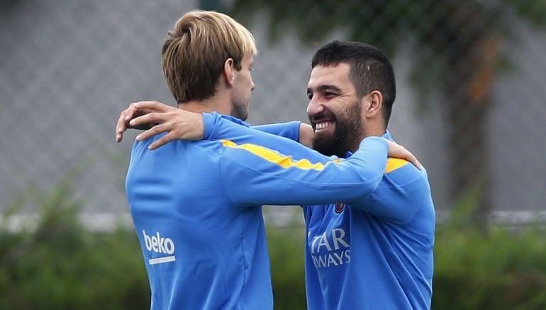 Los centrocampistas del FC Barcelona el croata Ivan Rakitic y el turco Arda Turan, durante el entrenamiento que el conjunto azulgrana 