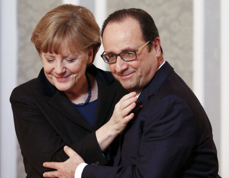 German Chancellor Angela Merkel (L) embraces French President Francois Hollande during a meeting with the media after peace talks on resolving the Ukrainian crisis in Minsk, in this February 12, 2015 file picture. Kiev, Moscow, Munich, Washington, Ottawa,