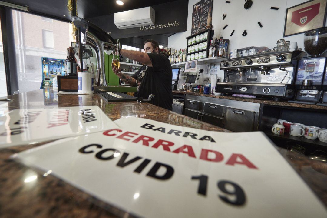 Un camarero en la barra cerrada de su bar el día en que han entrado en vigor nuevas restricciones por el coronavirus, a 29 de diciembre, en Pamplona, Navarra