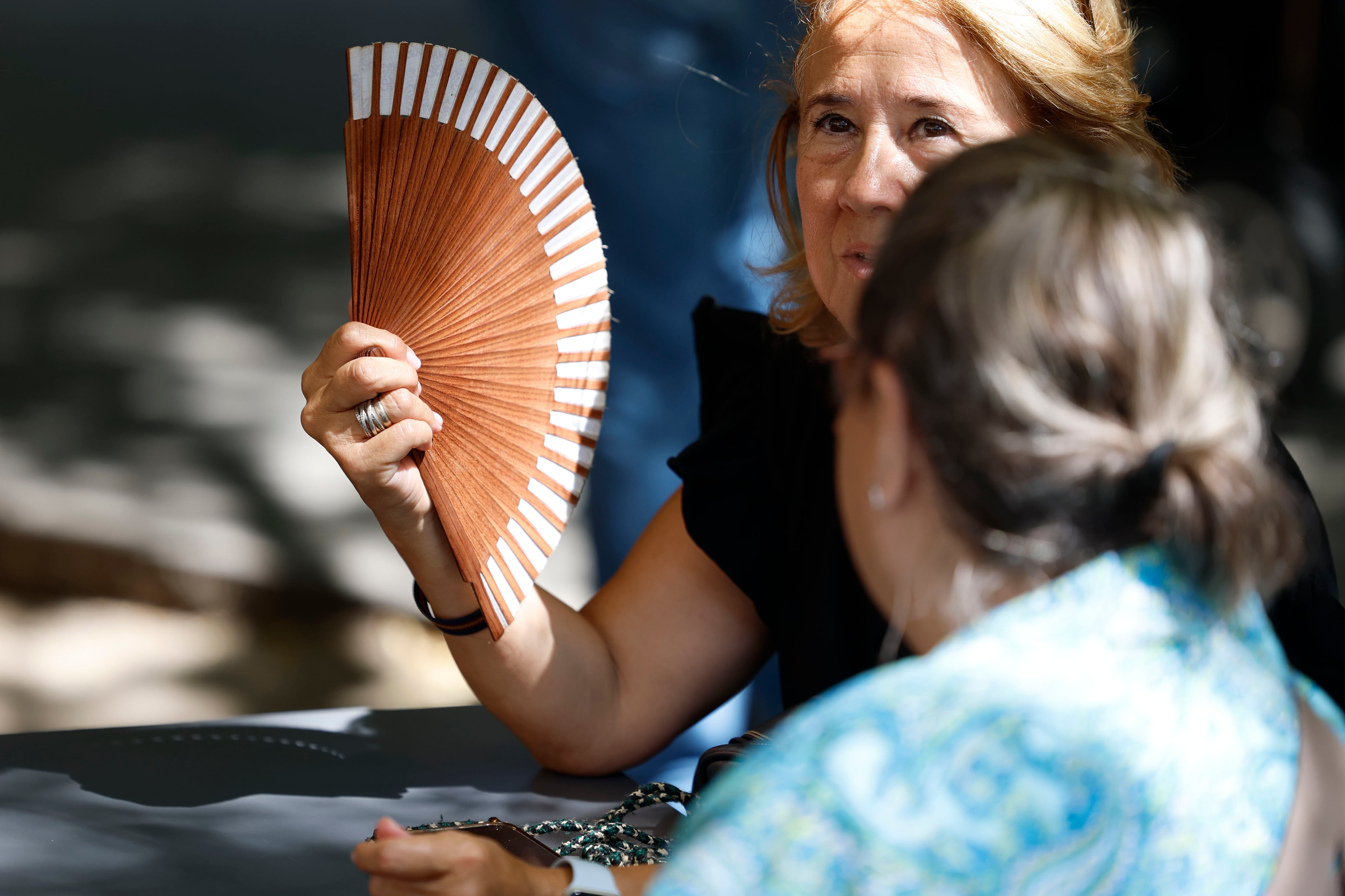 Una mujer se abanica para intentar mitigar las altas temperaturas que se registran este miércoles en Madrid.