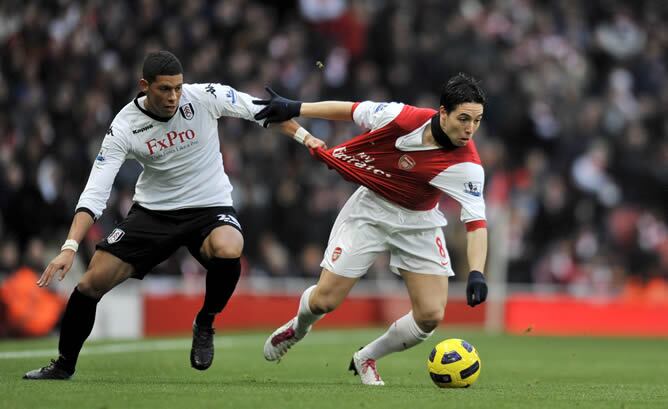 El jugador del Fulham Matthew Briggs tira de la camiseta al jugador del Arsenal, Samir Nasri, determinante en la victoria del Arsenal