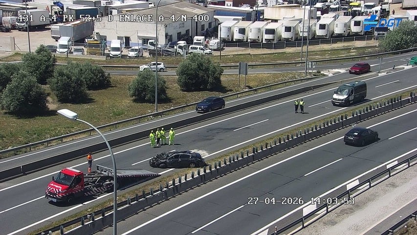 Imagen del vehículo volcado en la A-4, mientras es retirado por una grúa