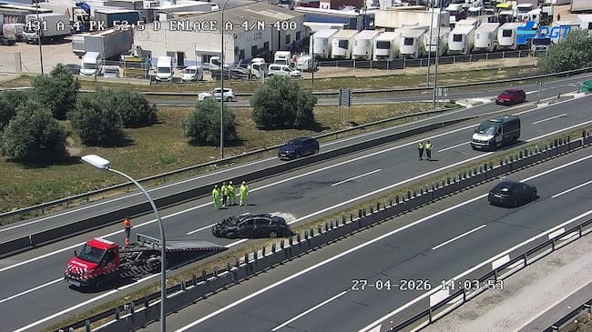 Imagen del vehículo volcado en la A-4, mientras es retirado por una grúa