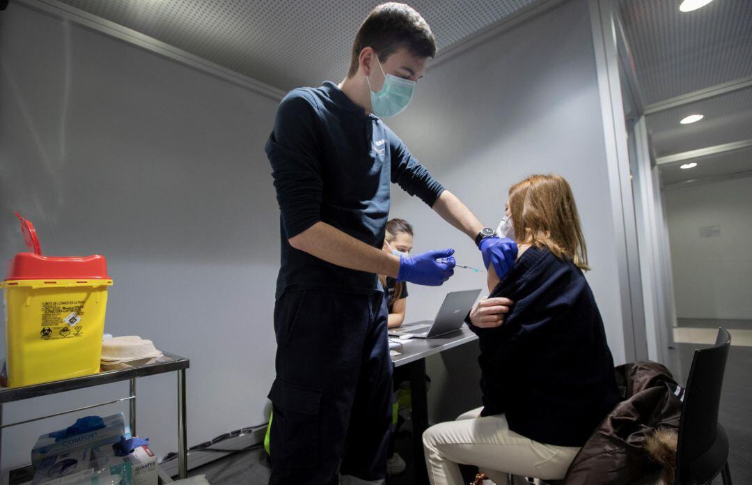Un enfermero administra la vacuna Pfizer a una sanitaria este sábado en las instalaciones de REFENA de Pamplona donde ha comenzado la vacunación contra la Covid-19 a personal sanitario del Servicio Navarro de Salud de la Comarca de Pamplona