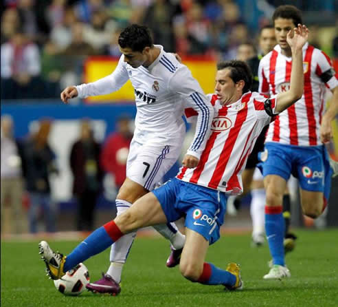 Cristiano Ronaldo pelea por el balón con el uruguayo Diego Godín