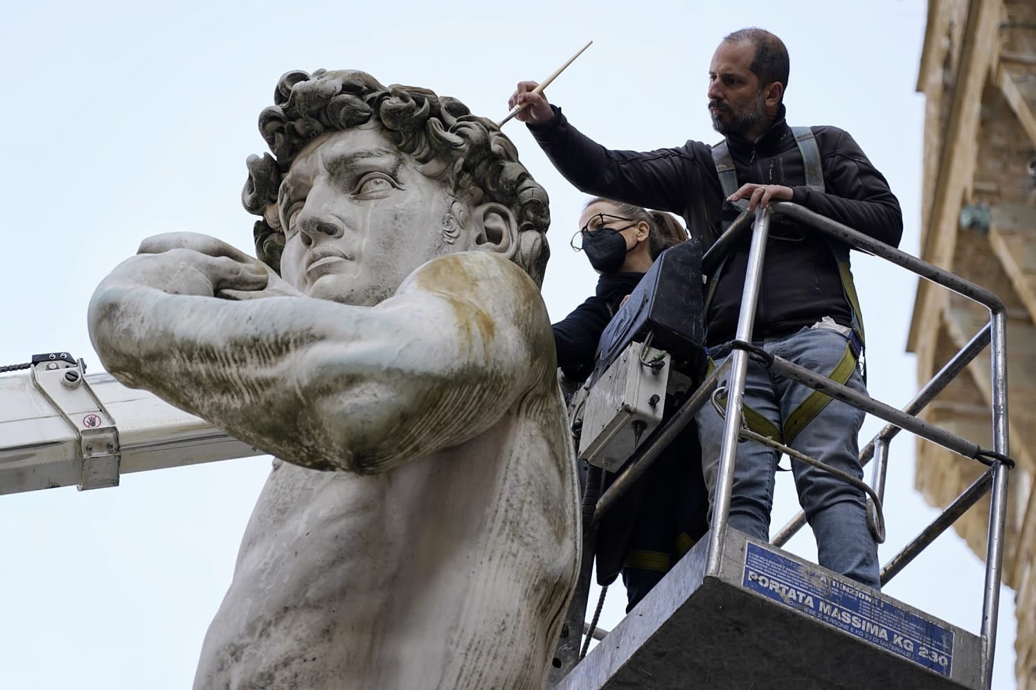 Técnicos del ayuntamiento de Florencia supervisan la copia del David de Miguel Ángel que se encuentra en la plaza de la Signoria y que ha sido incendiada por un sujeto que prendió fuego a una tela que la cubría desde hace algunos días en solidaridad con la guerra en Ucrania.