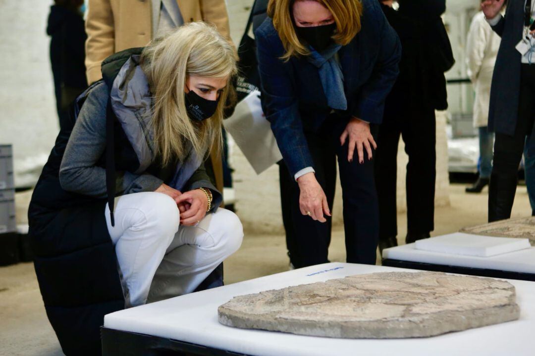 La consejera de Cultura, Patricia del Pozo, contempla en cuclillas una de las piezas del Arqueológico acompañada por la directora del Museo, María Soledad Gil 