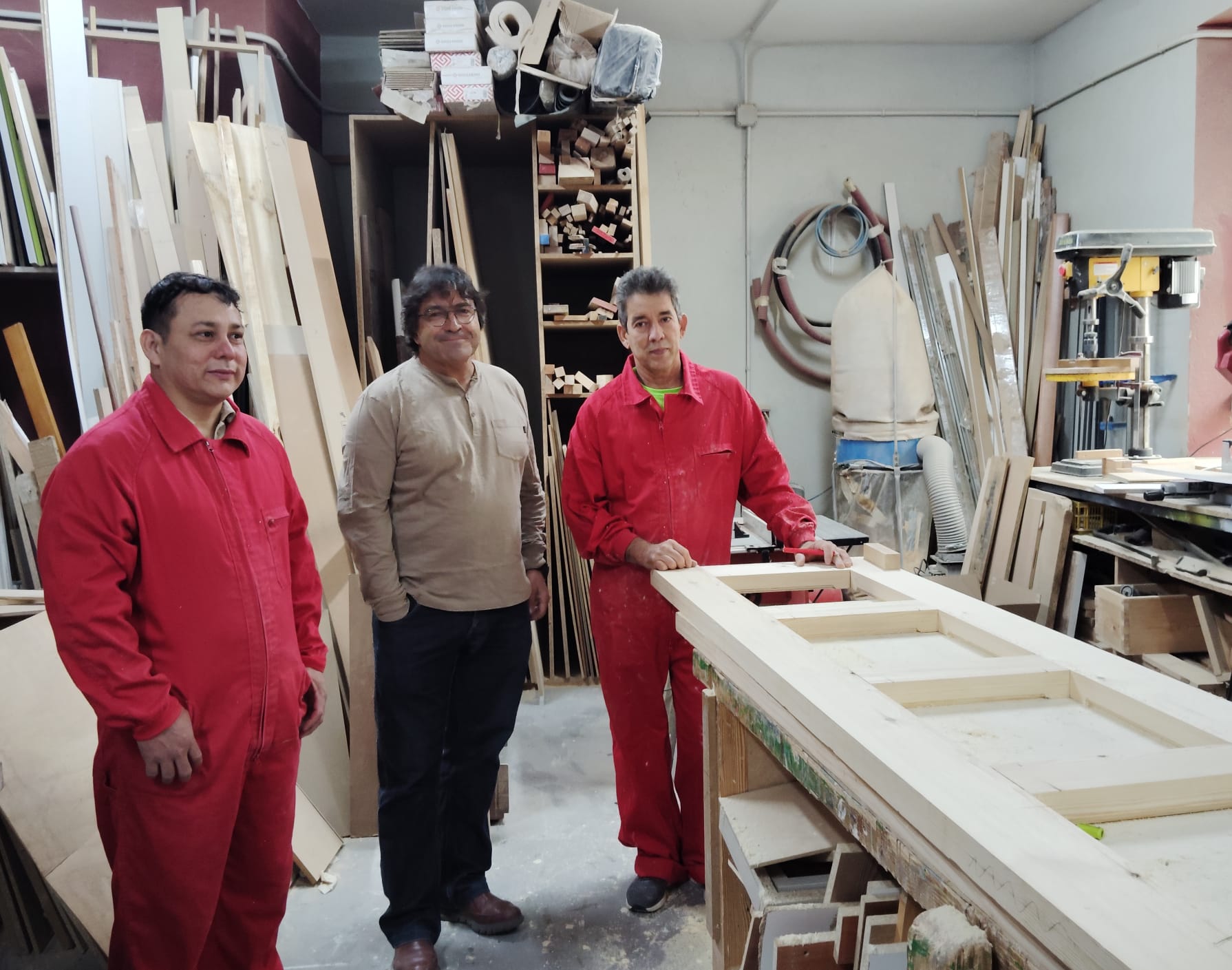 Jesús Gil, responsable del Programa de Empleo de Cáritas, con dos de los miembros del taller de carpintería