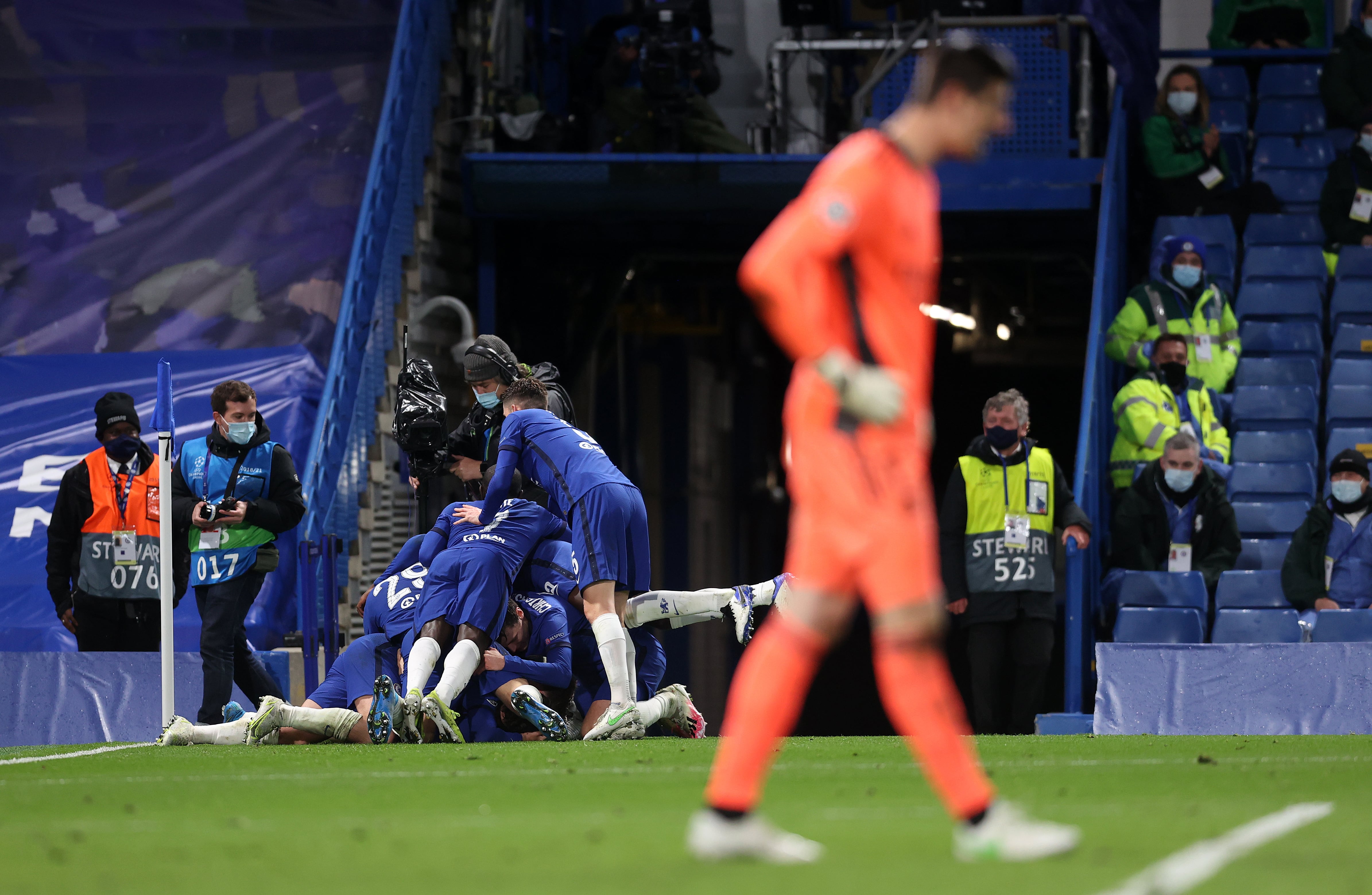 LONDON, ENGLAND - MAY 05: Mason Mount of Chelsea celebrates with teammates after scoring their team&#039;s second goal as Thibaut Courtois of Real Madrid looks dejected during the UEFA Champions League Semi Final Second Leg match between Chelsea and Real Madrid at Stamford Bridge on May 05, 2021 in London, England. Sporting stadiums around Europe remain under strict restrictions due to the Coronavirus Pandemic as Government social distancing laws prohibit fans inside venues resulting in games being played behind closed doors. (Photo by Clive Rose/Getty Images)