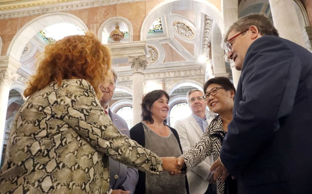 La Secretaria General de Global Social Economy Forum, Lawrence Kwuark, (2d) saluda a los concejales en presencia del alcalde de Bilbao, Juan Mari Aburto, (d), durante la presentación de la celebración de GSEF BILBAO 2018, el mayor foro internacional sobre