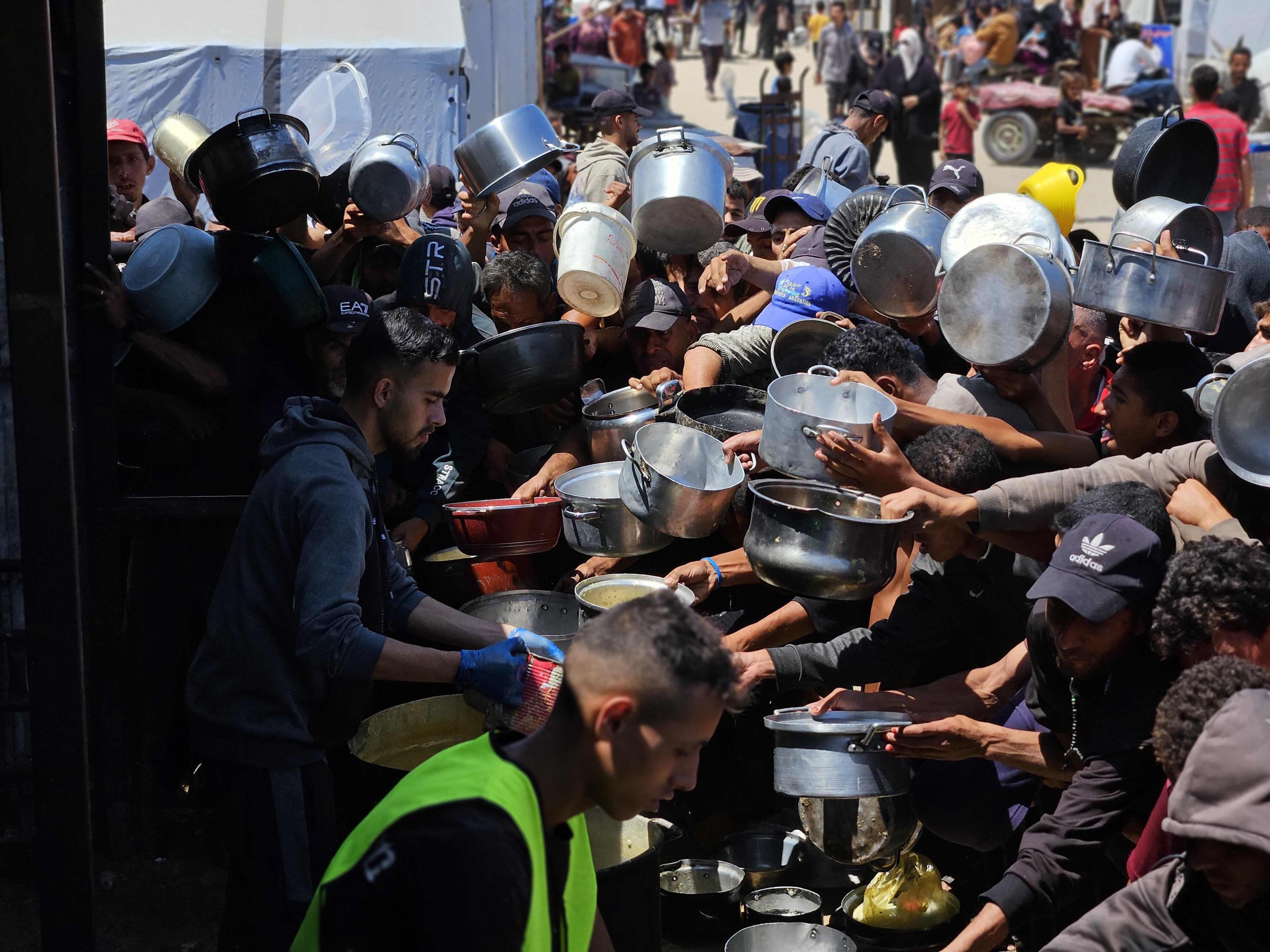 Palestinos esperan en colas para recibir comida de las organizaciones humanitarias