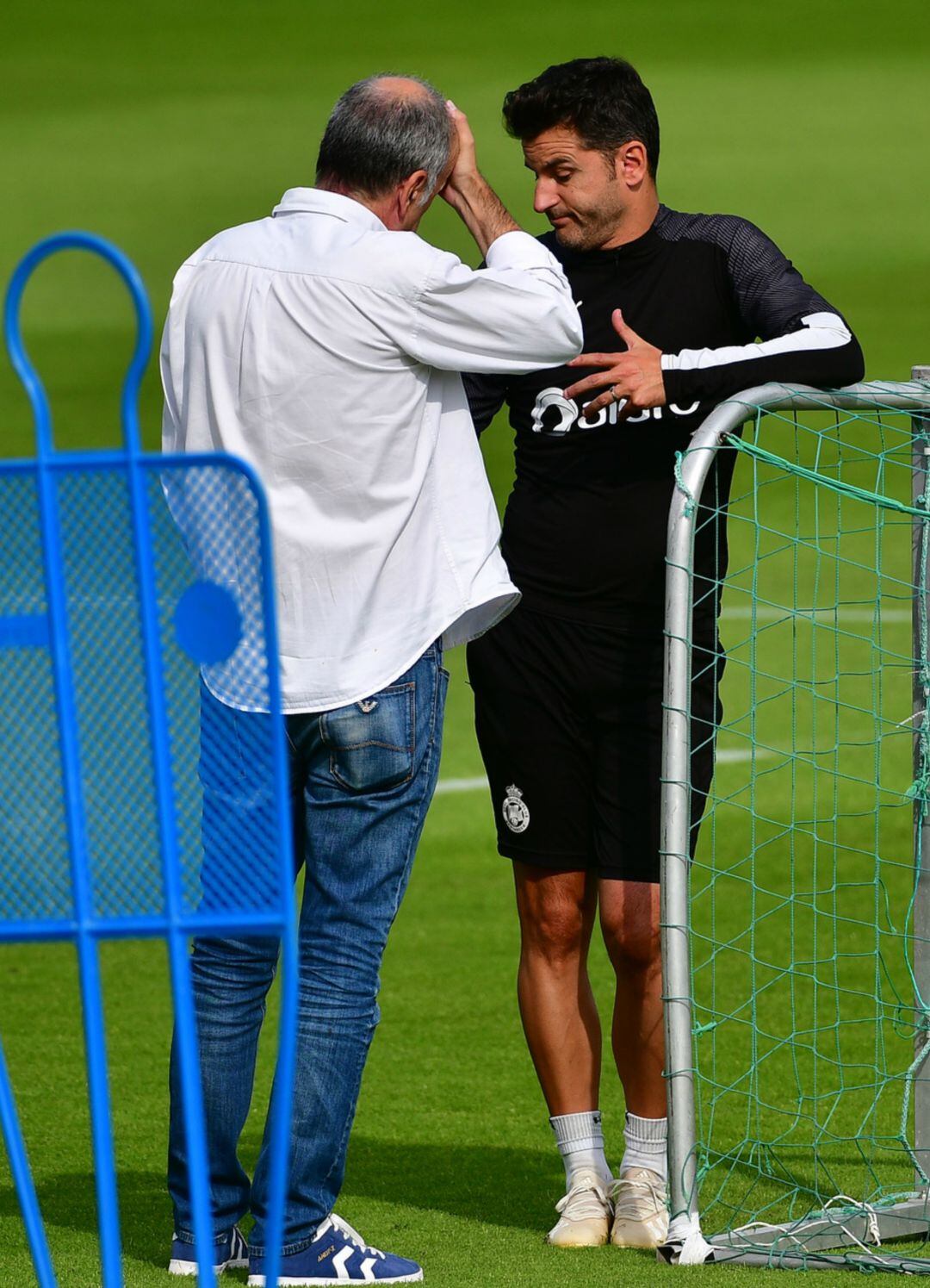 En entrenador y el médico del Racing, intercambiando opiniones.