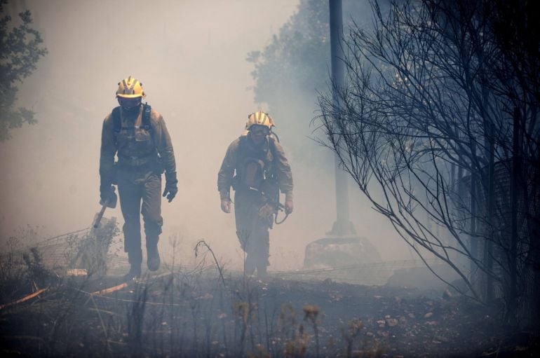 OURENSE- Varios bomberos trabajan en las labores de extinción del incendio detectado hoy en la parroquia de Canedo. 