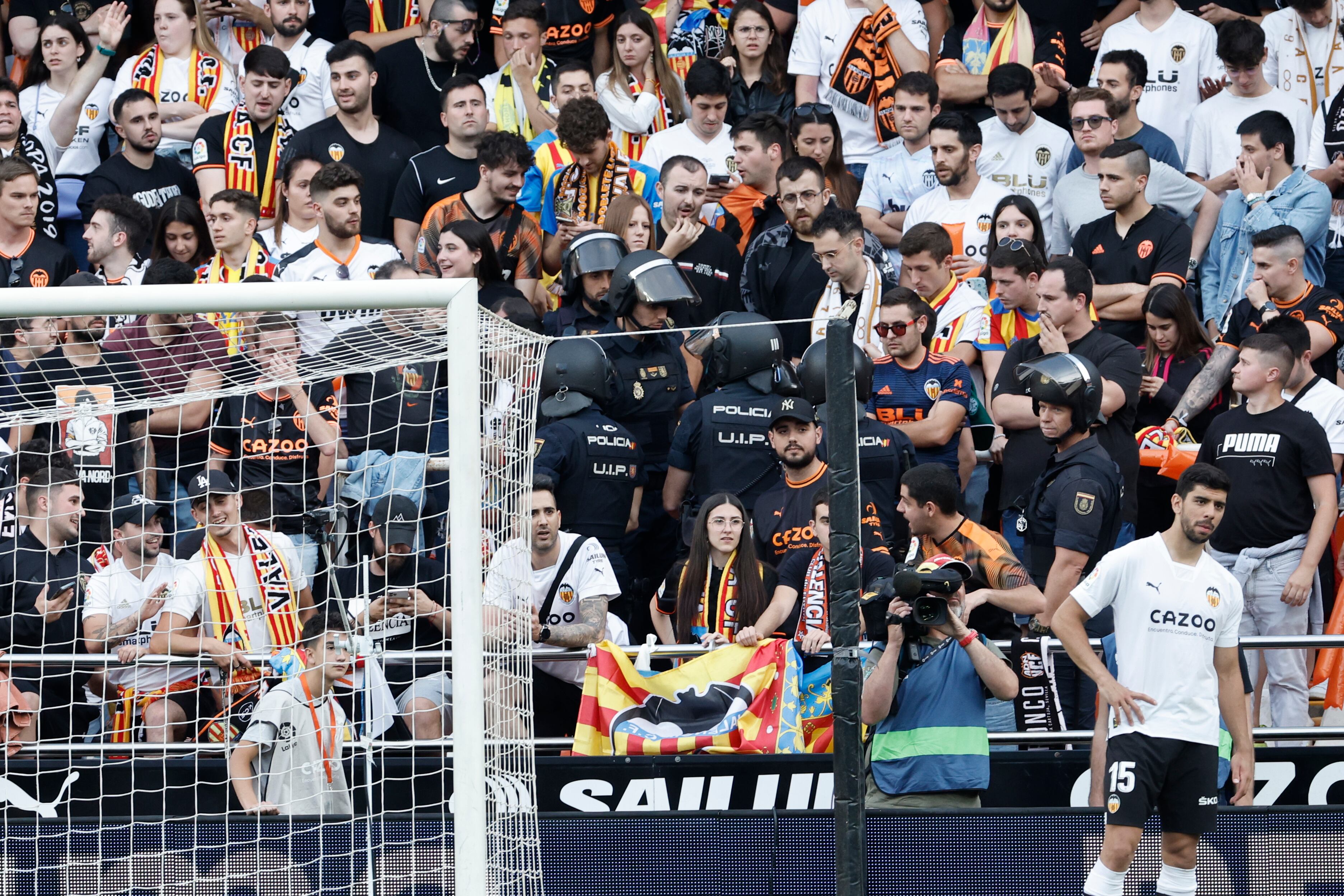 La policía interviene en la grada durante la polémica en el campo de juego por un segundo esférico en el partido correspondiente a la jornada 35 de LaLiga Santander que disputan Valencia CF y Real Madrid este domingo en Mestalla (Valencia).