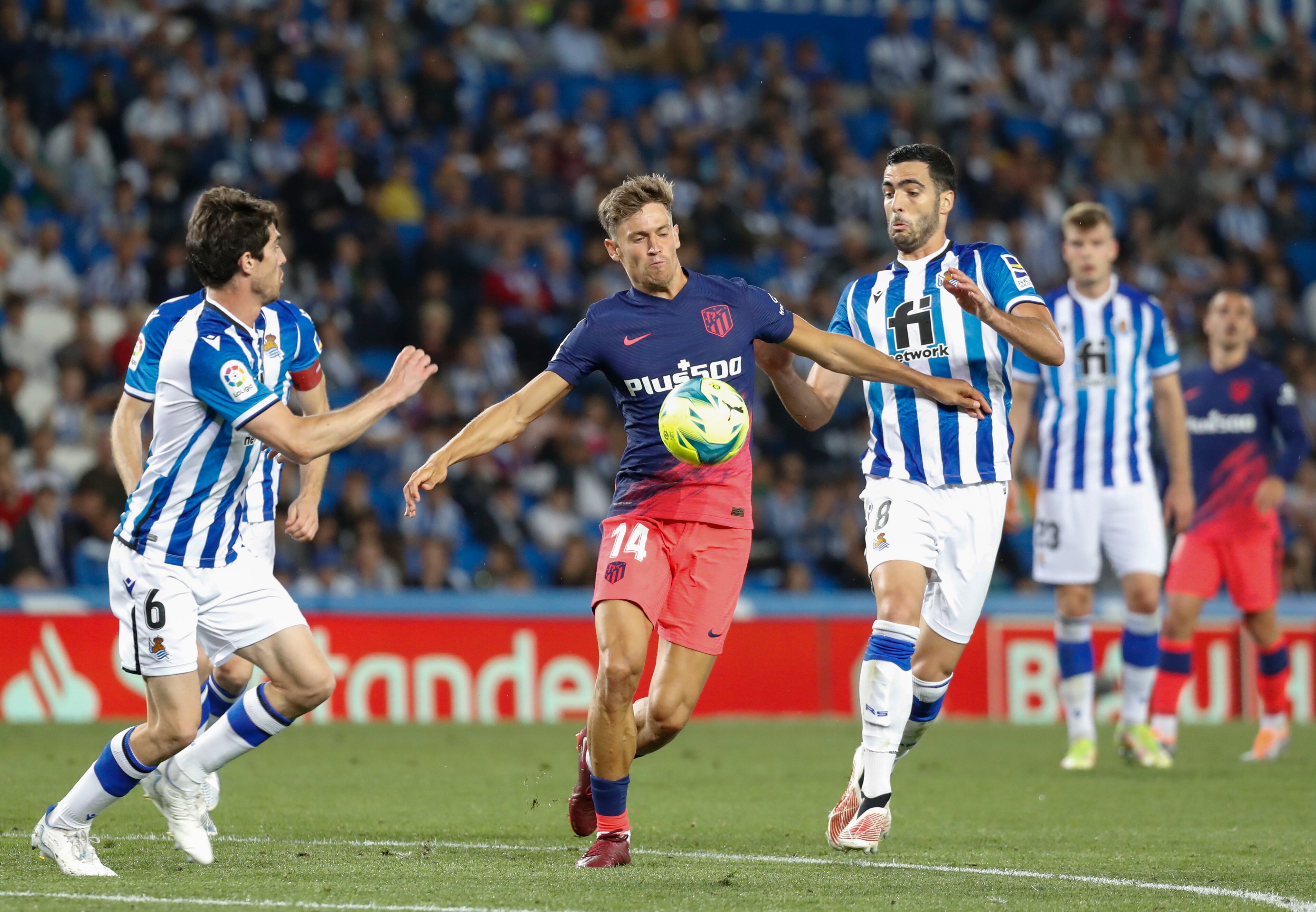 SAN SEBASTIÁN, 22/05/2022.- El centrocampista del Atlético de Madrid Marcos Llorente (c) lucha con Aritz Elustondo (i) y con Mikel Merino (d), ambos de la Real Sociedad, durante el partido de la jornada 38 de Liga en Primera División que Real Sociedad y Atlético de Madrid disputan hoy domingo en el Reale Arena. EFE/Juan Herrero
