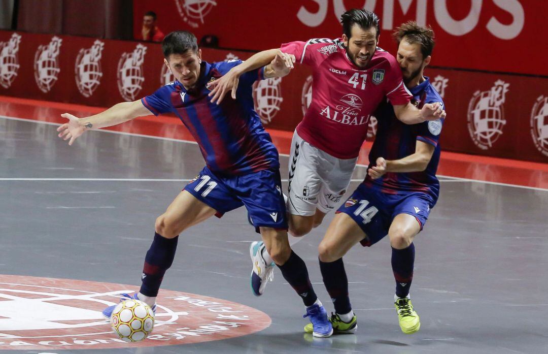 El jugador del Viña Albali Valdepeñas Rafael Rato pelea por el balón con los jugadores del Levante &quot;Gallo&quot; y Javier Sena, durante la segunda semifinal del Play Off Exprés por el título de Campeón de Liga