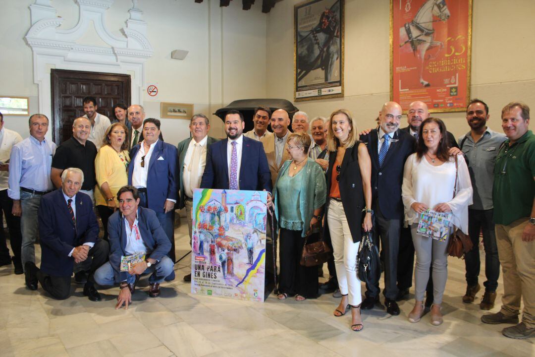 El alcalde de Gines, Romualdo Garrido, sostiene el cartel de la XIII edición de la &#039;Pará&#039; tras su presentación en el Museo de Carruajes de Sevilla 