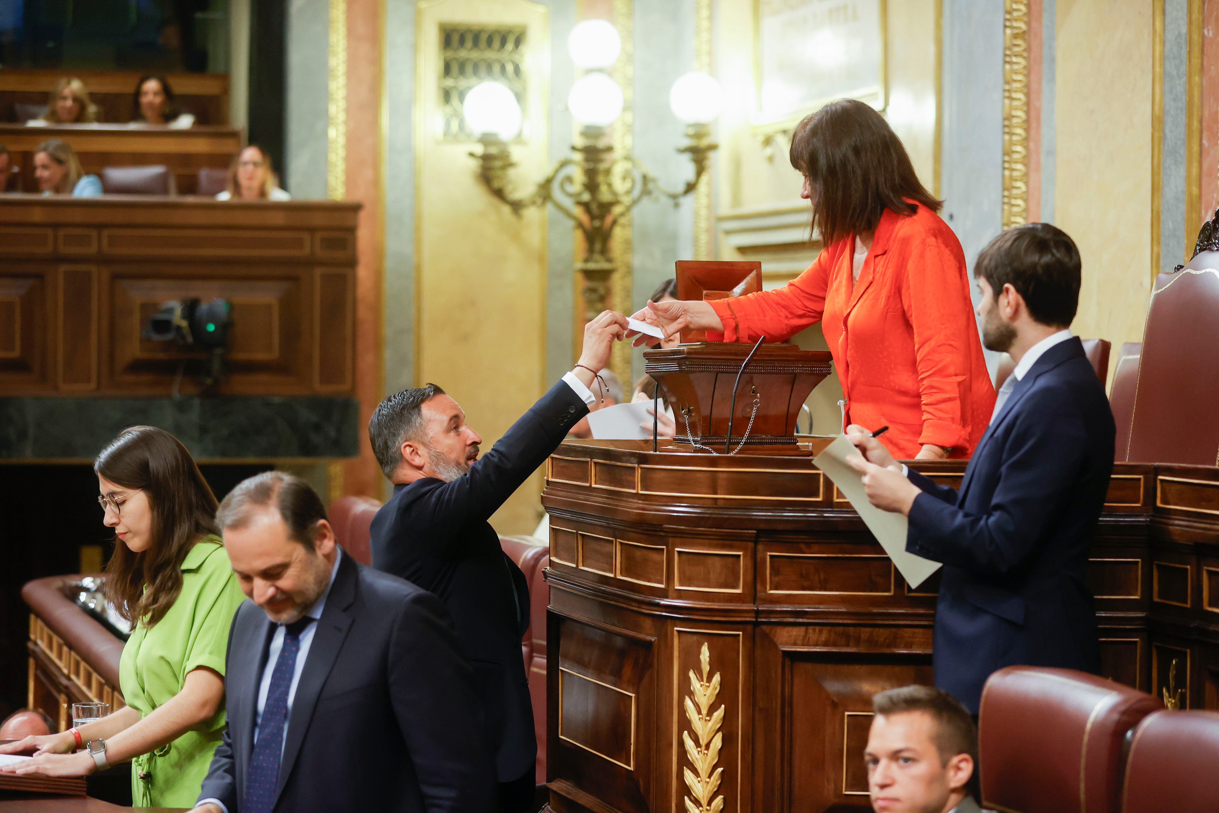 La diputada socialista Cristina Narbona (2d), parlamentaria de mayor edad, recoge la papeleta del diputado de Vox Santiago Abascal (c) durante la votación de la mesa en el Congreso de los Diputados.