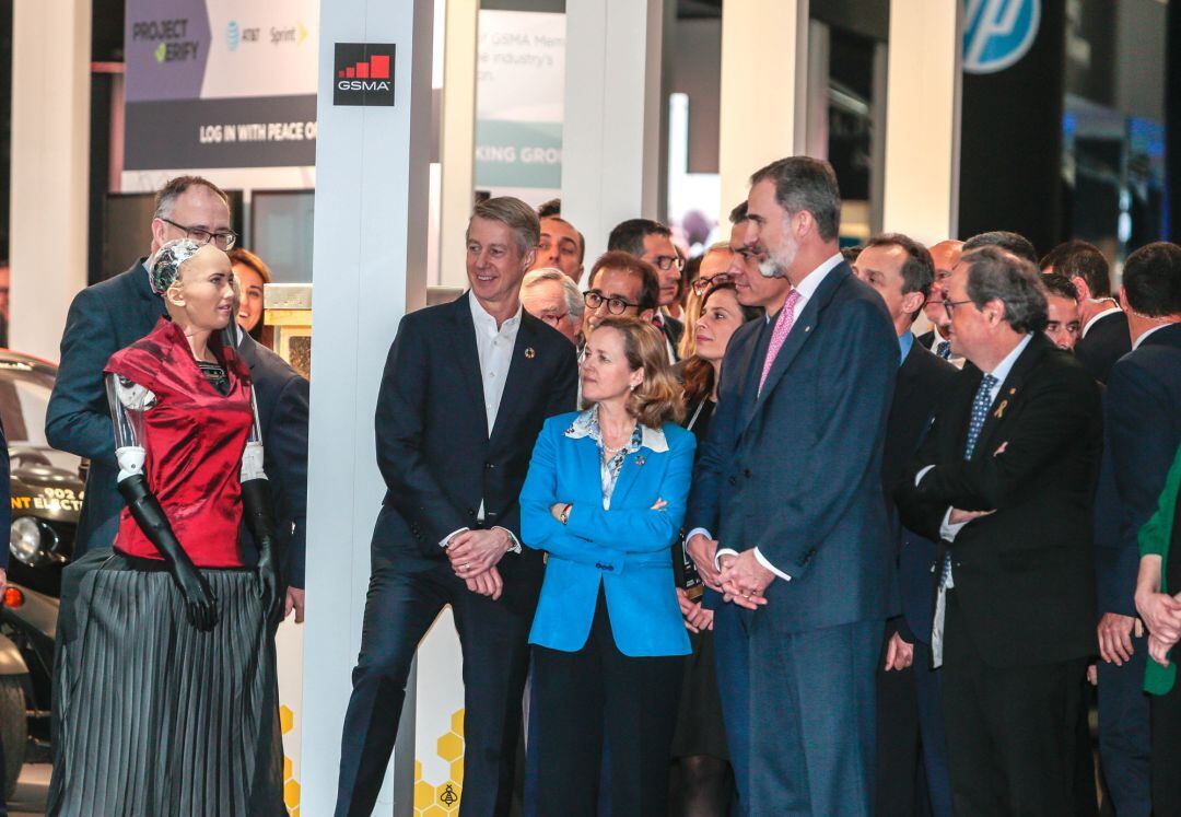 El Rey Felipe VI junto a la ministra Calviño y el president Torra observan el robot Sophia.