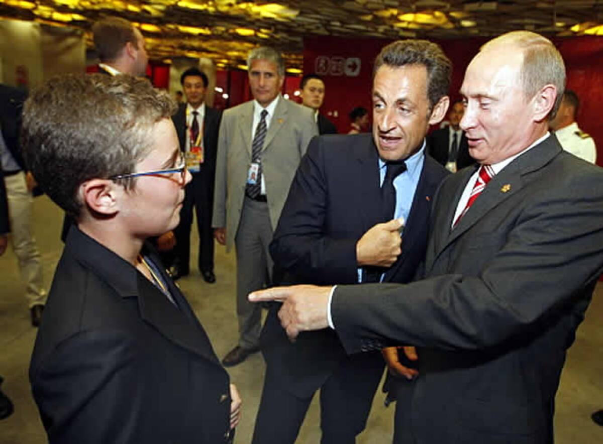 El presidente de la República francesa, Nicolas Sarkozy, le presenta a su hijo Louis a su homólogo ruso, Vladimir Putin, minutos antes de que comience la ceremonia