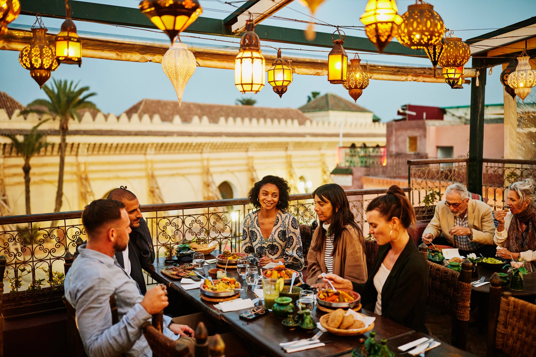 Un grupo de amigos comparte una cena en una terraza ubicada en la azotea de un edificio