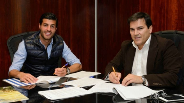 Miguel Torres firmando su nuevo contrato con el director general del Málaga Vicente Casado