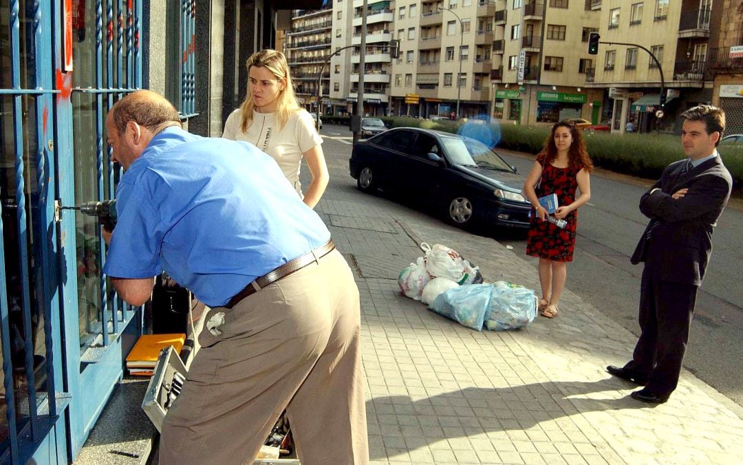 Un operario procede a reparar una cerradura forzada