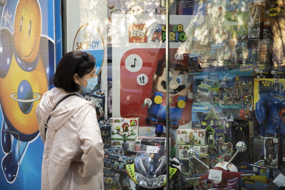 Archivo - Una mujer observa un escaparate de una juguetería.