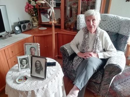 María Huerta Monje en su casa de Entrevías con las fotos de su juventud y la de su marido