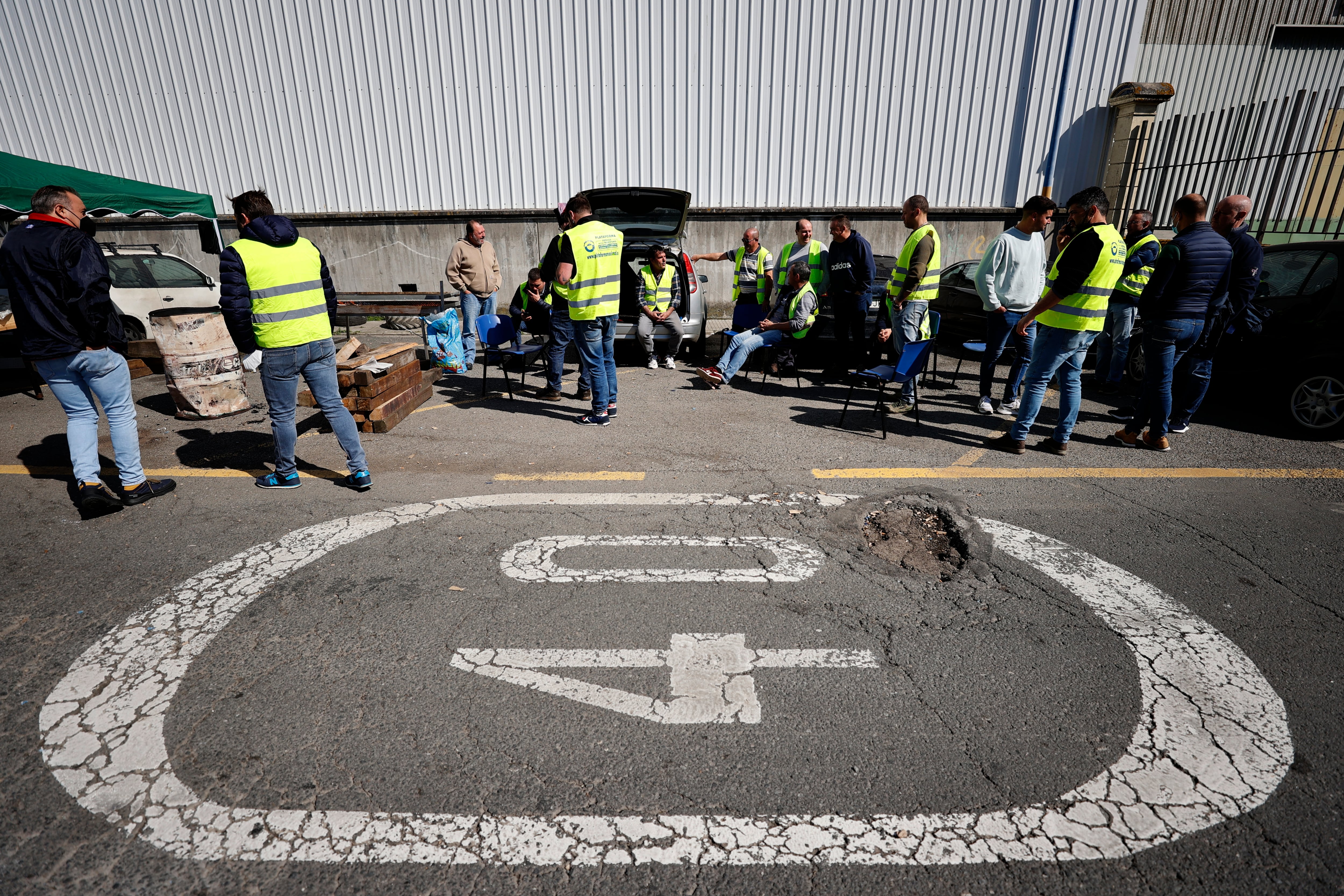 Varios camioneros participan en un piquete informativo instalado a la entrada del puerto de A Coruña, este jueves, donde continúan con la huelga en el sector del transporte convocada por la Plataforma de la Plataforma en Defensa del Sector del Transporte de Mercancías por Carretera Nacional e Internacional. EFE/Cabalar