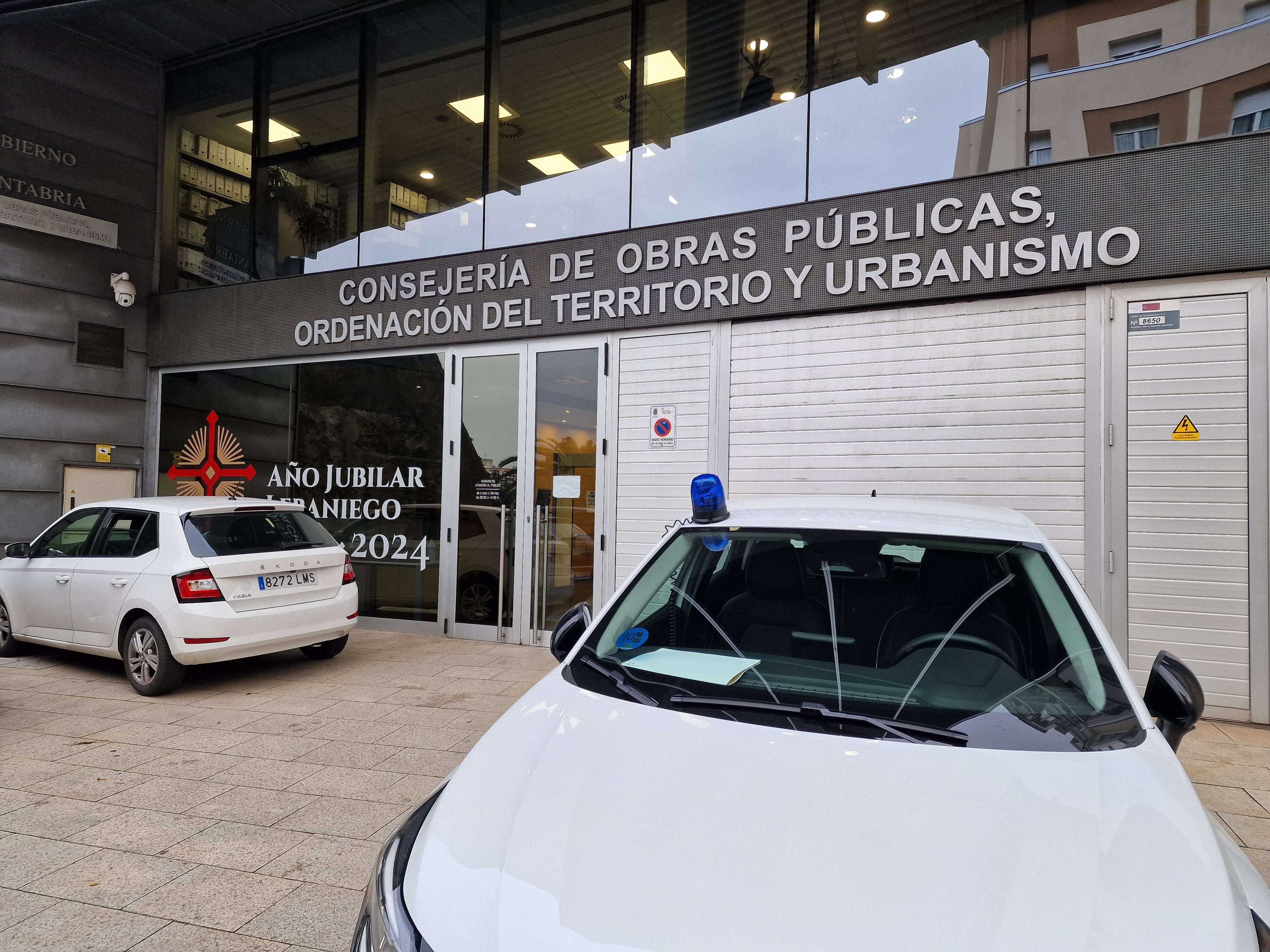 Un vehículo policial estacionado a las puertas de la sede de la Consejería de Obras Públicas y Ordenación del Territorio de Cantabria.