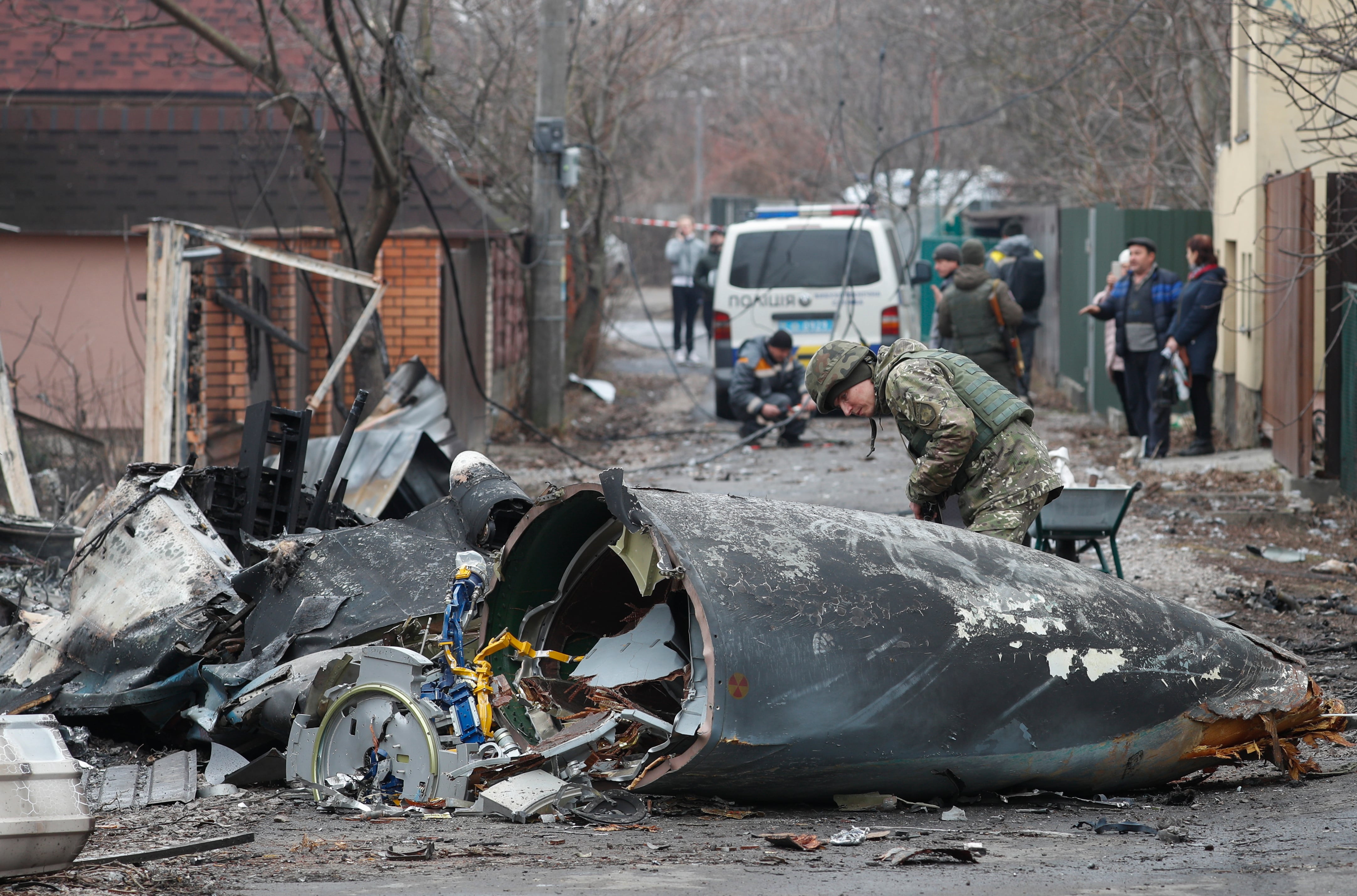 Un soldado observa los restos de un avión militar derribado en Kiev.