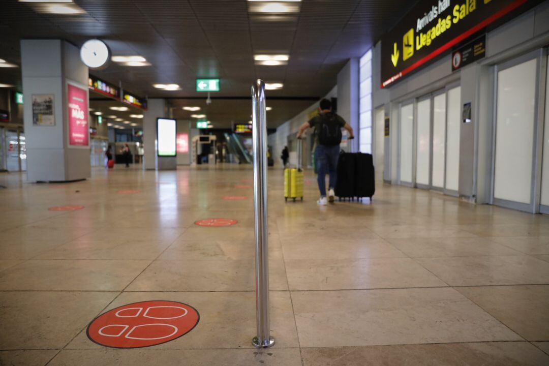 Pasajeros abandonan una de las salidas de la sala de llegadas de la Terminal 1 del Aeropuerto de Barajas, en Madrid