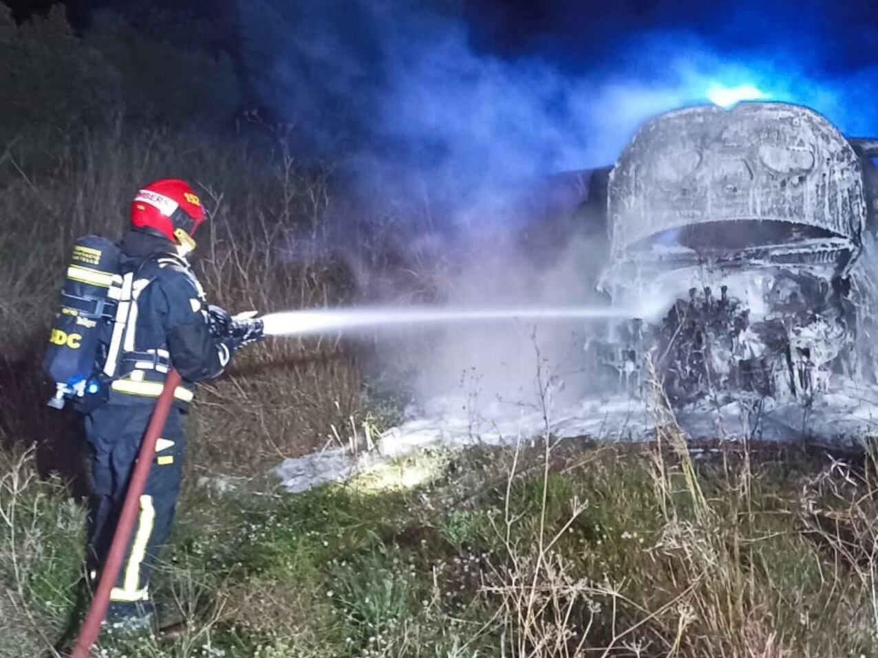 Un Bombero trabajando en la extinción del fuego del vehículo