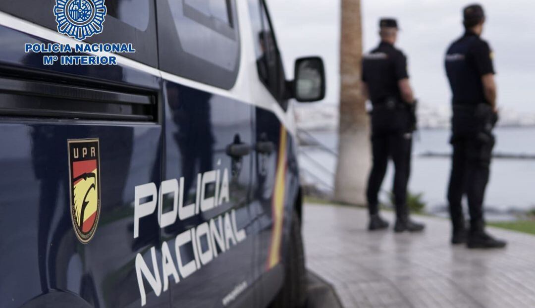 Agentes de la Policía Nacional junto a un coche patrulla