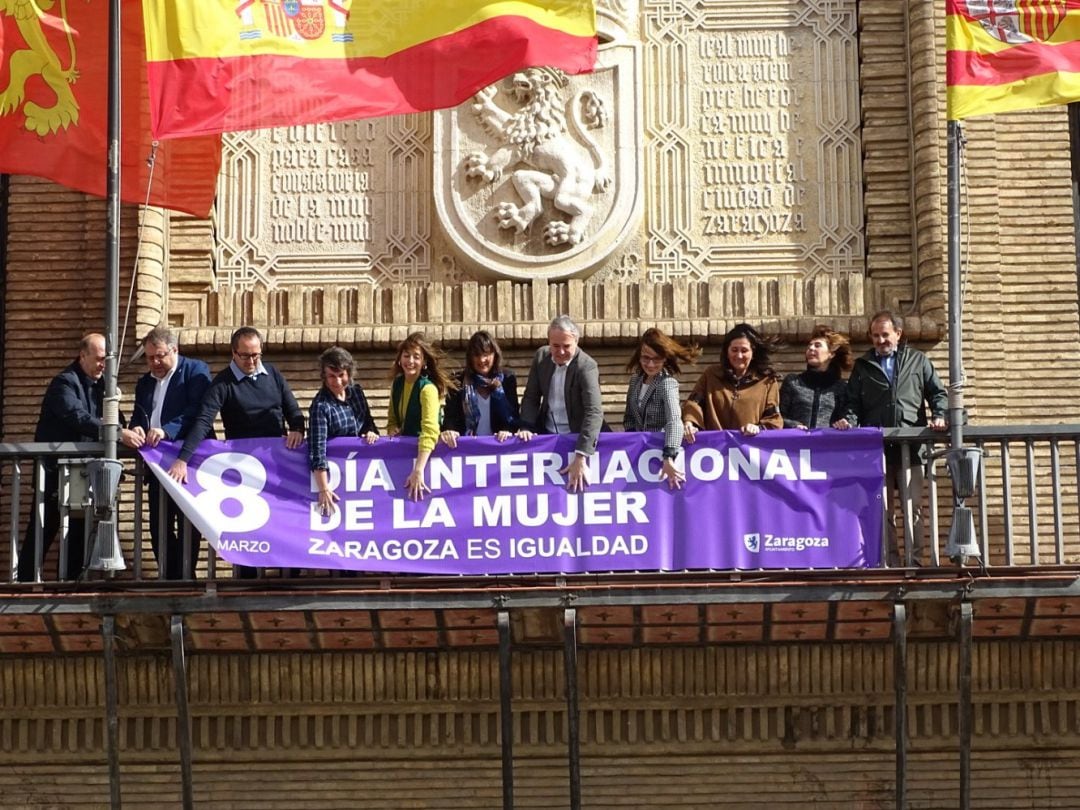 Colocación de la pancarta del 8 de marzo en el Ayuntamiento de Zaragoza, con concejales de PP, Ciudadanos, PSOE y Zaragoza en Común